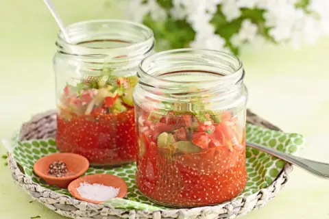 Zwei Gläser mit Tomaten-Chiasamen-Mischung, inspiriert von gesunden Chiasamen Rezepten. Daneben kleine Schälchen mit Salz und Pfeffer.