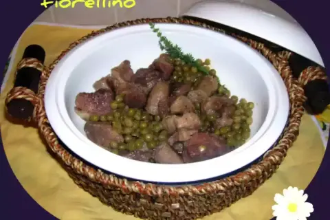 Un invitante spezzatino di maiale con piselli, servito in una ciotola bianca con manici intrecciati.