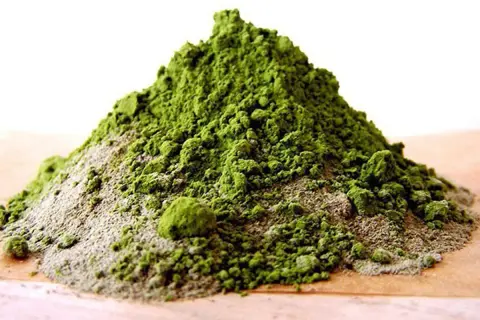 Montículo de arcilla verde en polvo, ideal para mascarillas faciales y tratamientos de belleza.