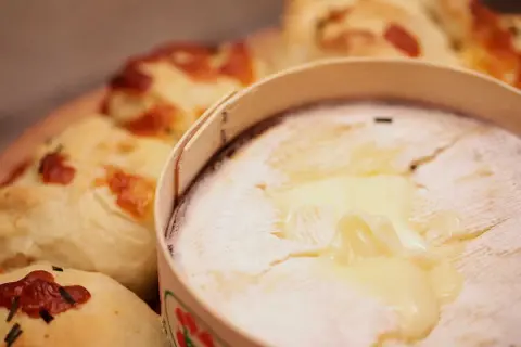 Un Mont d'Or fondant, prêt à être dégusté avec du pain croustillant. Parfait pour un repas convivial.