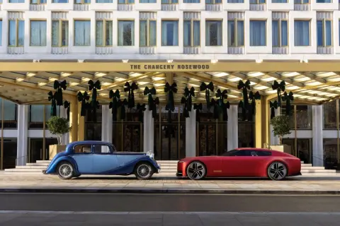 En blå klassisk brittisk sportbil ss bredvid en röd modern sportbil framför The Chancery Rosewood.