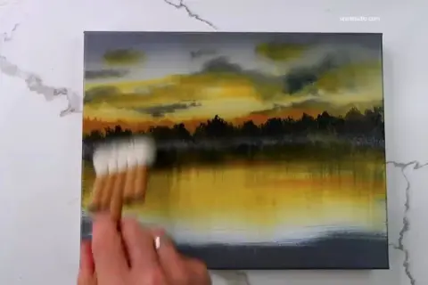 Peinture au scotch d'un paysage au coucher du soleil, avec des nuages orangés et jaunes reflétés dans l'eau.