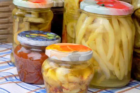 Słoiki z przetworami, w tym fasolką i dżemem, przygotowane metodą tyndalizacji w piekarniku.