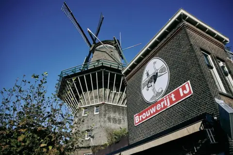 Mulino a vento accanto alla Brouwerij 't IJ, con il suo iconico logo struzzo.