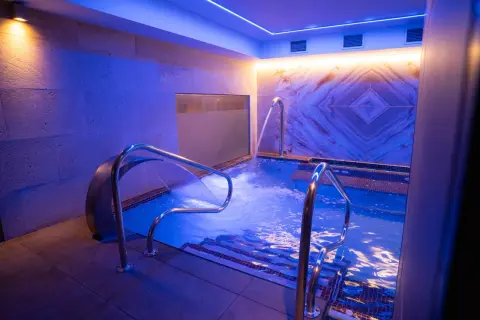 Relájate en este circuito spa con cascadas de agua y luces azules.