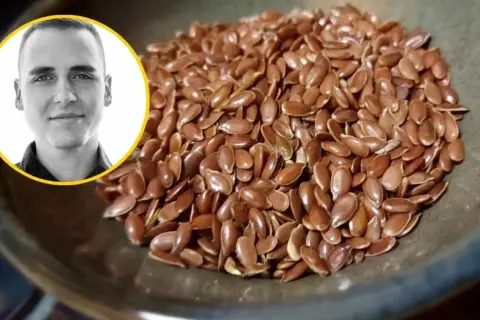 Mężczyzna z uśmiechem obok miseczki pełnej siemienia lnianego. Czy siemię lniane obniża cholesterol? Dowiedz się więcej!