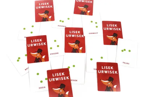 Karty z gry "Lisek Urwisek grają" rozsypane na białym tle. Wesoły lisek w cylindrze zachęca do zabawy.