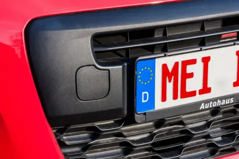 Rotes Kennzeichen "MEI IF" an einem roten Auto, bereit für das Fahrtenbuch.