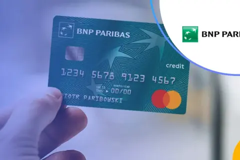 Dłoń trzyma zieloną kartę kredytową BNP Paribas. Bezpieczne BNP Paribas płatność kartą za granicą.