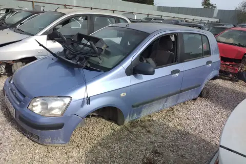 Desguace de un Hyundai Getz 1.1. El coche está en un desguace, sin ruedas y con partes rotas, evidenciando sus problemas.