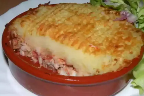 Un parmentier de poisson gastronomique, gratiné et servi avec une salade verte. Un délice réconfortant.