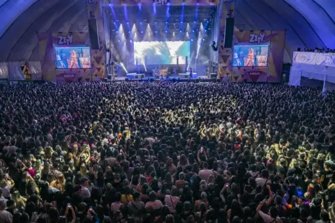Gran concierto con un aforo masivo en un espacio Zity. Miles de personas disfrutan de la música bajo luces y pantallas gigantes.