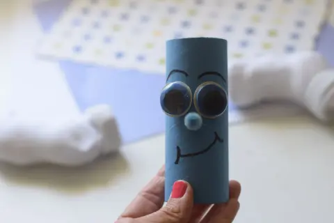 Un pitufo filósofo, dibujo hecho con un rollo de papel azul, ojos saltones y una sonrisa pensativa.