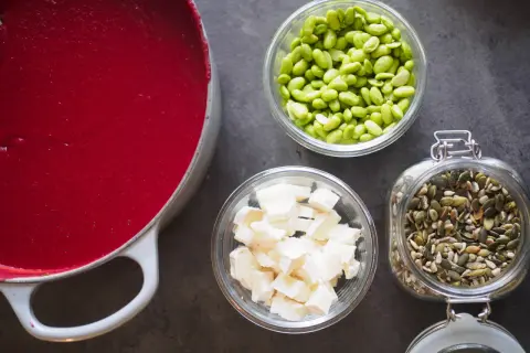 Röd soppa i gryta, edamamebönor, ost och fröblandning. Enkla ingredienser för att leva billigt mat.