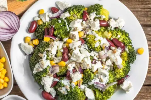 Ensalada fresca de brócoli, frijoles rojos, maíz y queso feta, perfecta para los menús de verano.