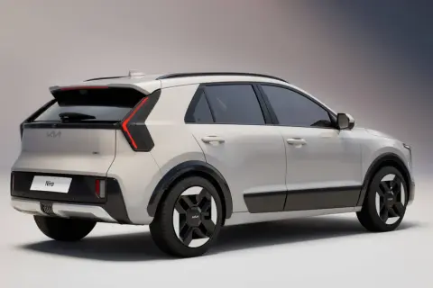 Nowy Kia Niro w kolorze jasnoszarym, widok z tyłu i boku. Stylowe światła LED i czarne detale podkreślają nowoczesny design.