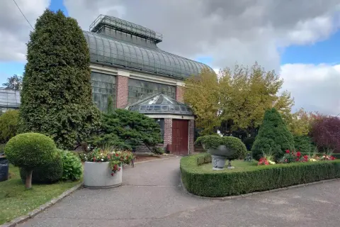 Piękna palmiarnia Wałbrzych otoczona zadbaną zielenią i kwiatami.
