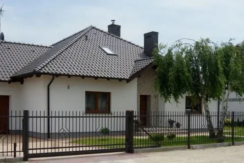 Nowy, nowoczesny dom z czarnym, metalowym ogrodzeniem. Czy to ogrodzenie bez pozwolenia?