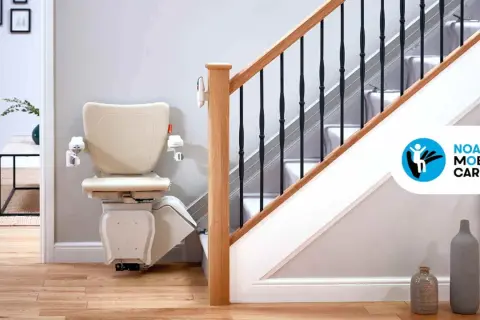 Installazione montascale beige su una scala con corrimano in legno e ringhiera nera. La soluzione ideale per la mobilità in casa.
