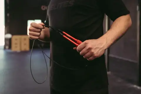 Mann hält ein rotes Springseil. Die richtige Länge ist entscheidend für ein gutes Training.