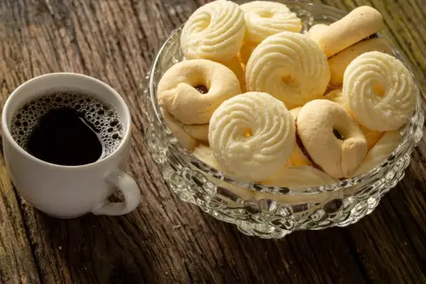 Kawa i miseczka pełna pysznych, delikatnych ciastek. Idealne na chwilę relaksu.