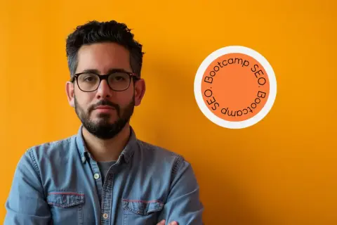 Homme confiant, lunettes, chemise en jean, devant un mur orange. Logo "SEO Bootcamp" suggérant une formation SEO diplômante.