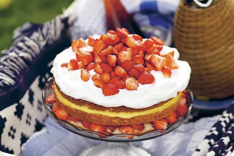 En härlig jordgubbstårta med fluffig grädde och en syrlig lemoncurdfyllning, dekorerad med färska jordgubbar. Perfekt för sommaren!