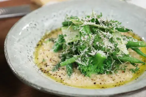 Krämig risotto med grönsaker, toppad med parmesan och färska örter. Ett perfekt risotto recept för en lätt lunch.