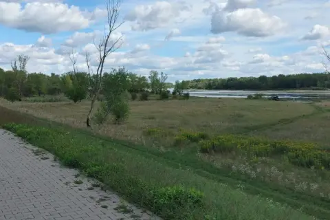 Asfaltowa ścieżka wzdłuż rzeki, idealna na spacer. Stężyca trasa oferuje piękne widoki na zieleń i wodę.