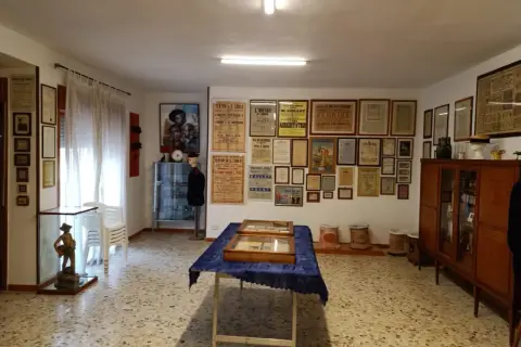 Interno del museo di Napoli, collezione Bonelli, con locandine teatrali d'epoca alle pareti e vetrine espositive.