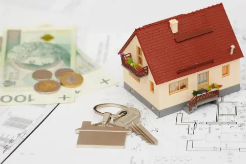 Model domu, klucze, pieniądze i plany architektoniczne. To wszystko składa się na wstępny kosztorys budowy wymarzonego domu.