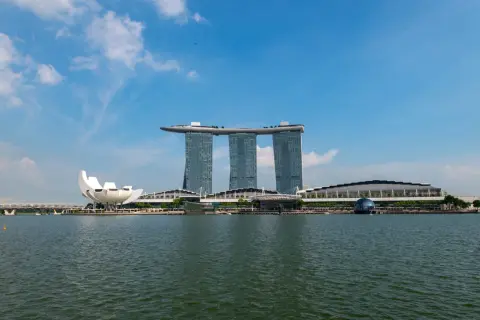 Widok na Marina Bay Sands, gdzie jest Singapur. Woda, nowoczesne budynki i niebieskie niebo.
