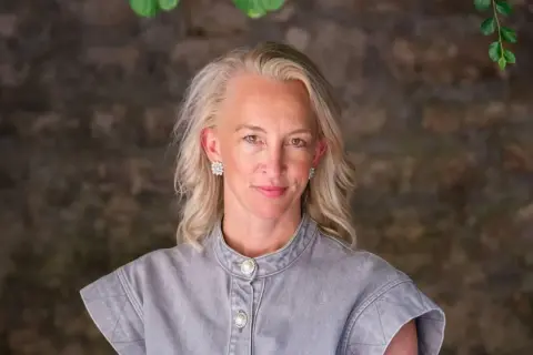 Anna Wikland, med blont hår och gnistrande örhängen, ler mot kameran.