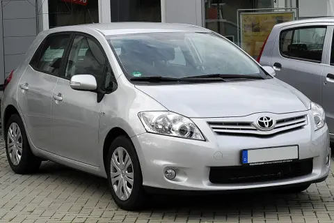 Srebrny Toyota Auris 1.6 benzyna zaparkowany na kostce brukowej.