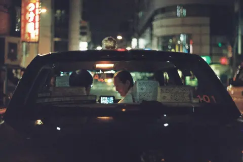 Taxi driver illuminated by a phone screen, a perfect shot for the best 35mm film for low light.