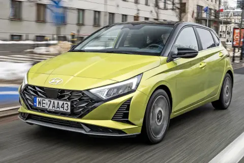 Żółty Hyundai i20 w ruchu miejskim. Sprawdź aktualną hyundai i20 cena i wybierz swój wymarzony samochód.