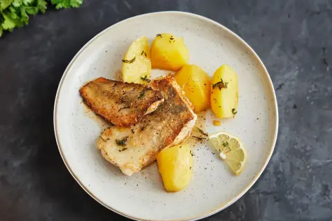 Gebratene Fischfilets mit Salzkartoffeln und Zitrone – so einfach lässt sich eine köstliche Fischplatte selber machen.