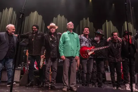 Zespół muzyczny na scenie, w tym Bill Murray w zielonej koszuli, gotowy na koncerty.