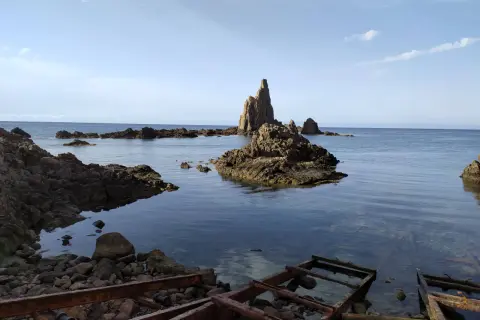 Rocas emergiendo del mar azul, un paisaje que evoca el mirador de las sirenas.