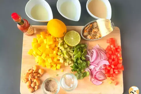 Mise en place para ceviche: mango, aguacate, cebolla morada, tomate, cilantro, limón, lima, mejillones en lata, maíz tostado, Tabasco y líquidos.