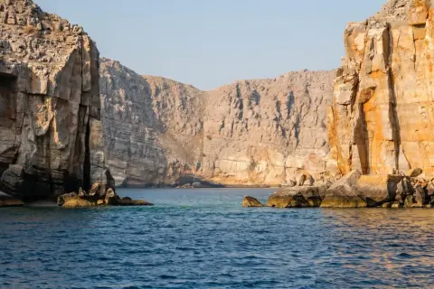 Majestätiska klippor reser sig ur det turkosa vattnet, en vy som påminner om en resa till Oman.