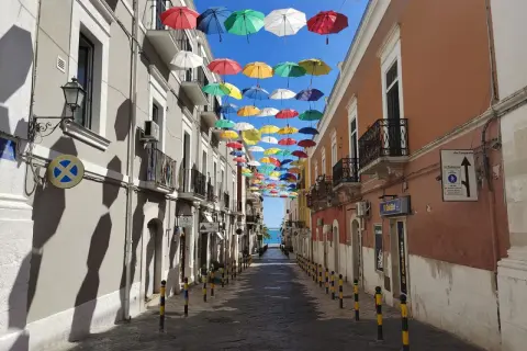 Un vicolo colorato da ombrelli sospesi, un'installazione artistica che rende unica Manfredonia. Ecco cosa vedere a Manfredonia per un'esperienza indimenticabile.