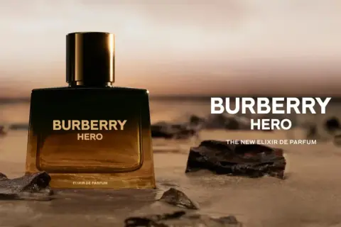 Elegancka butelka Burberry Hero na plaży, symbolizująca siłę i odwagę. Nowy Elixir de Parfum.