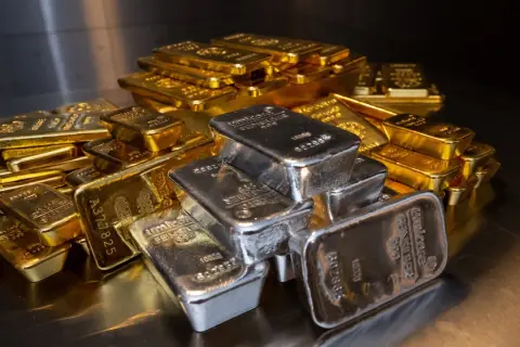 Montón de lingotes de oro y plata. El precio del oro usado hoy fluctúa con estas barras brillantes.