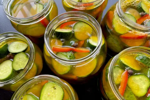 Słoiki pełne chrupiących ogórków z papryką i przyprawami, gotowe na zimę. Te ogórki w curry zachwycą smakiem!
