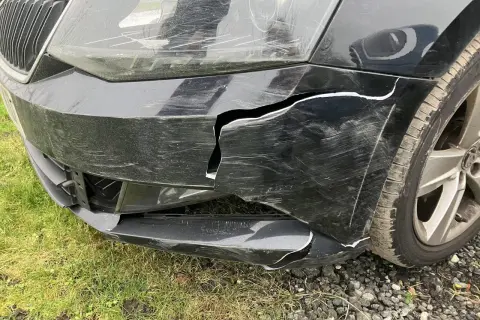 Usunięcie wypełnienia styropianowego spod zderzaka ujawniło pęknięcia i zarysowania na czarnym zderzaku samochodu.