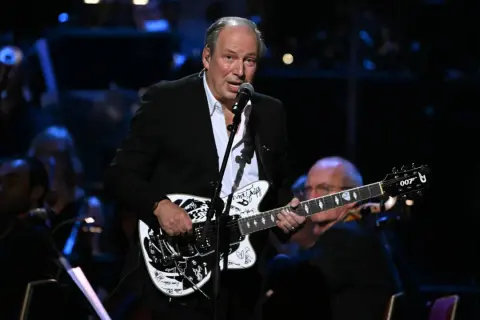 Hans Zimmer spielt auf einer Gitarre mit dem Bond-Logo. Seine beste Filmmusik erklingt live.