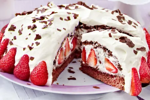 Saftige Stracciatella Torte mit frischen Erdbeeren und Schokostückchen, üppig mit Sahne verziert.