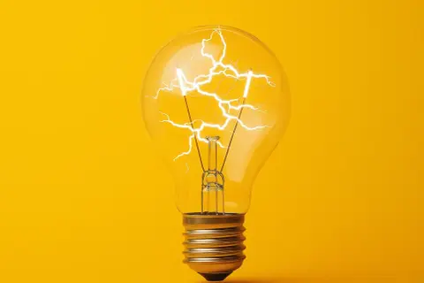 Żarówka z błyskawicami w środku, symbolizująca energię i pomysł. Jak obliczyć moc? To pytanie, na które odpowiedź może rozjaśnić umysł.