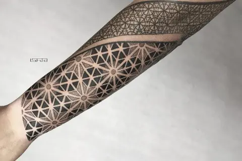 Geometryczny tatuaż dotwork na przedramieniu, tworzący hipnotyzujący wzór z trójkątów i kropek.